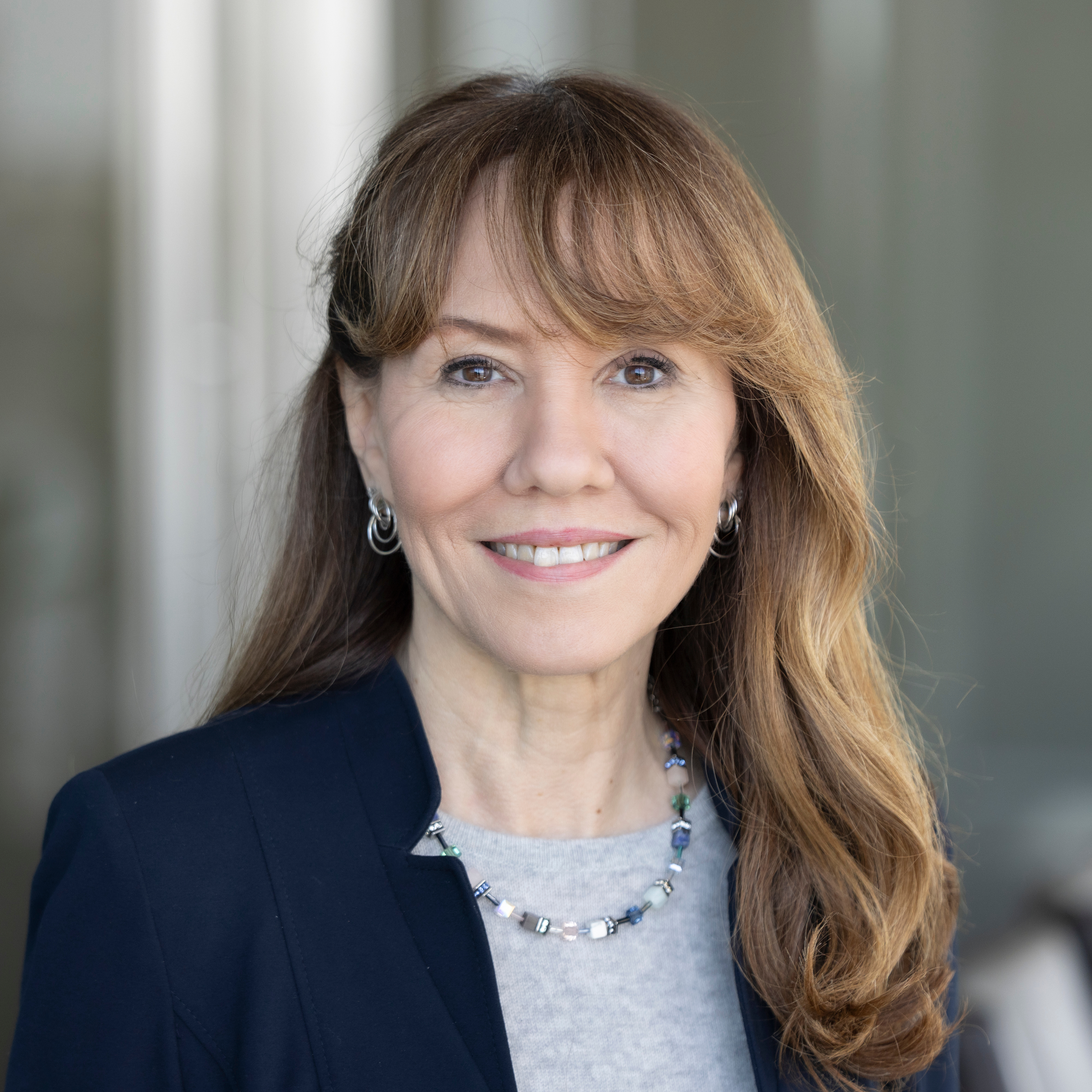 Portrait of a female, smiling and dressed in a business suit.