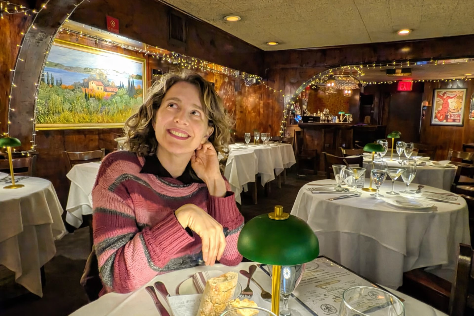 A woman sits at a table in a restaurant