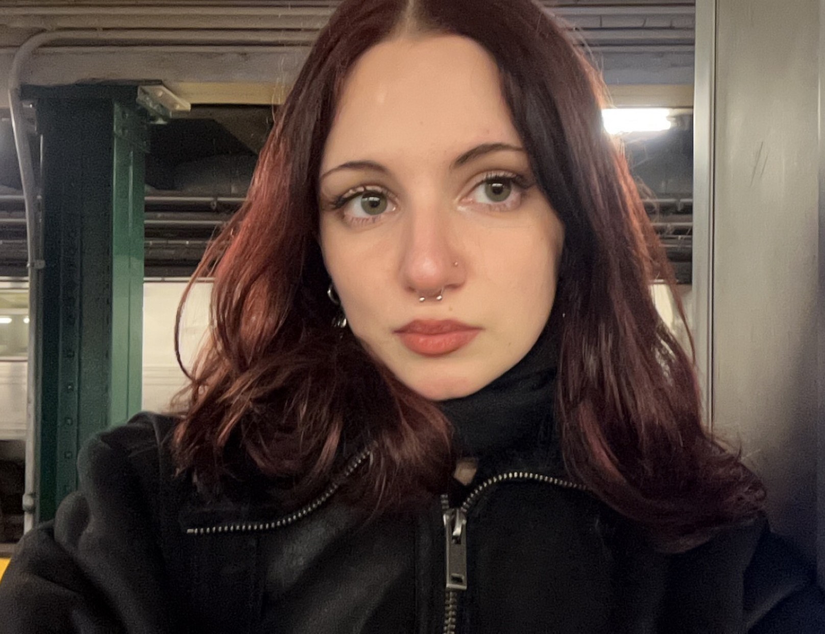 a woman with shoulder length hair standing in a subway car
