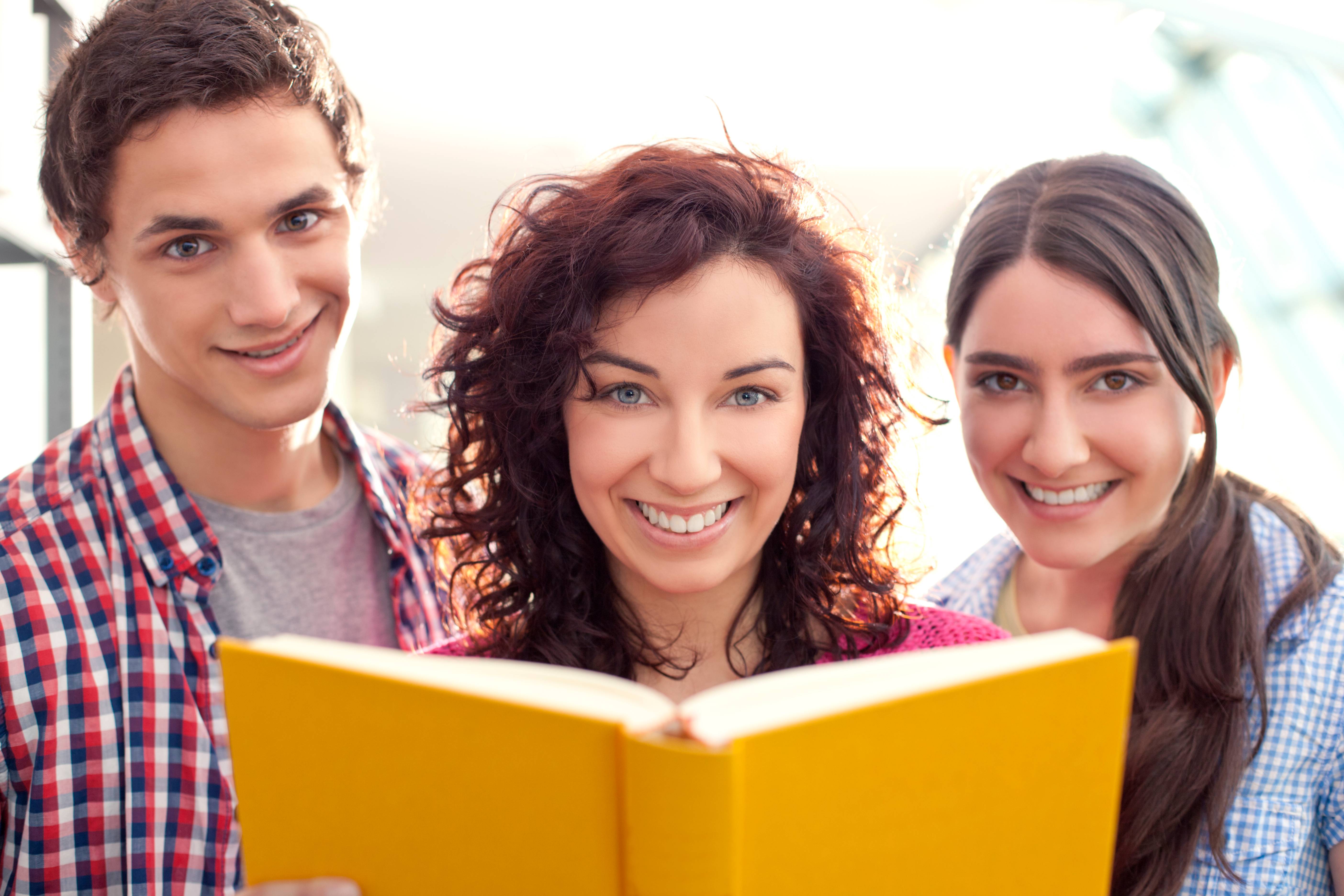 women reading a book with another man and another women reading over her shoulder.