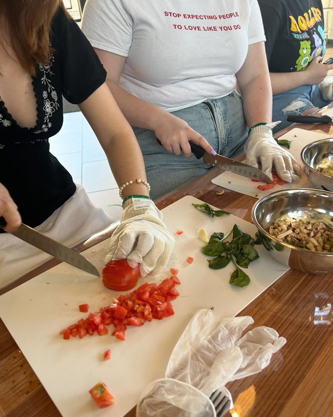 CIAO pasta making photo of the CIAO pasta making event. There are 2 members preparing pasta by slicing vegetables.